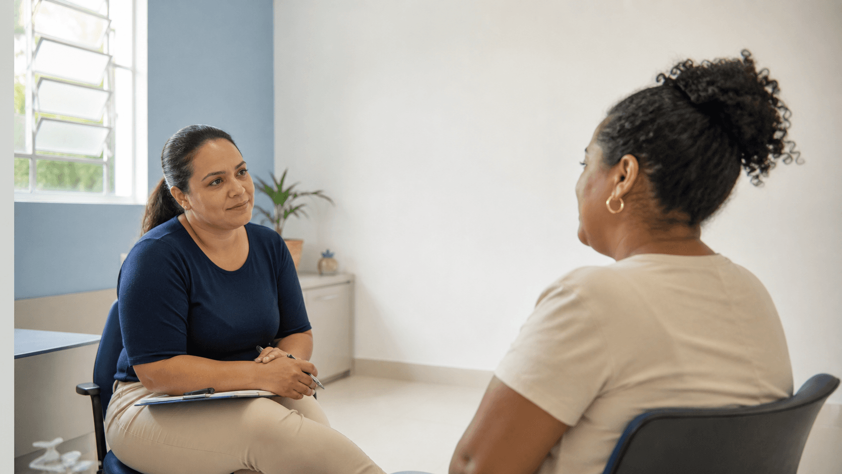 Profissional de saúde conversa com uma mulher em atendimento